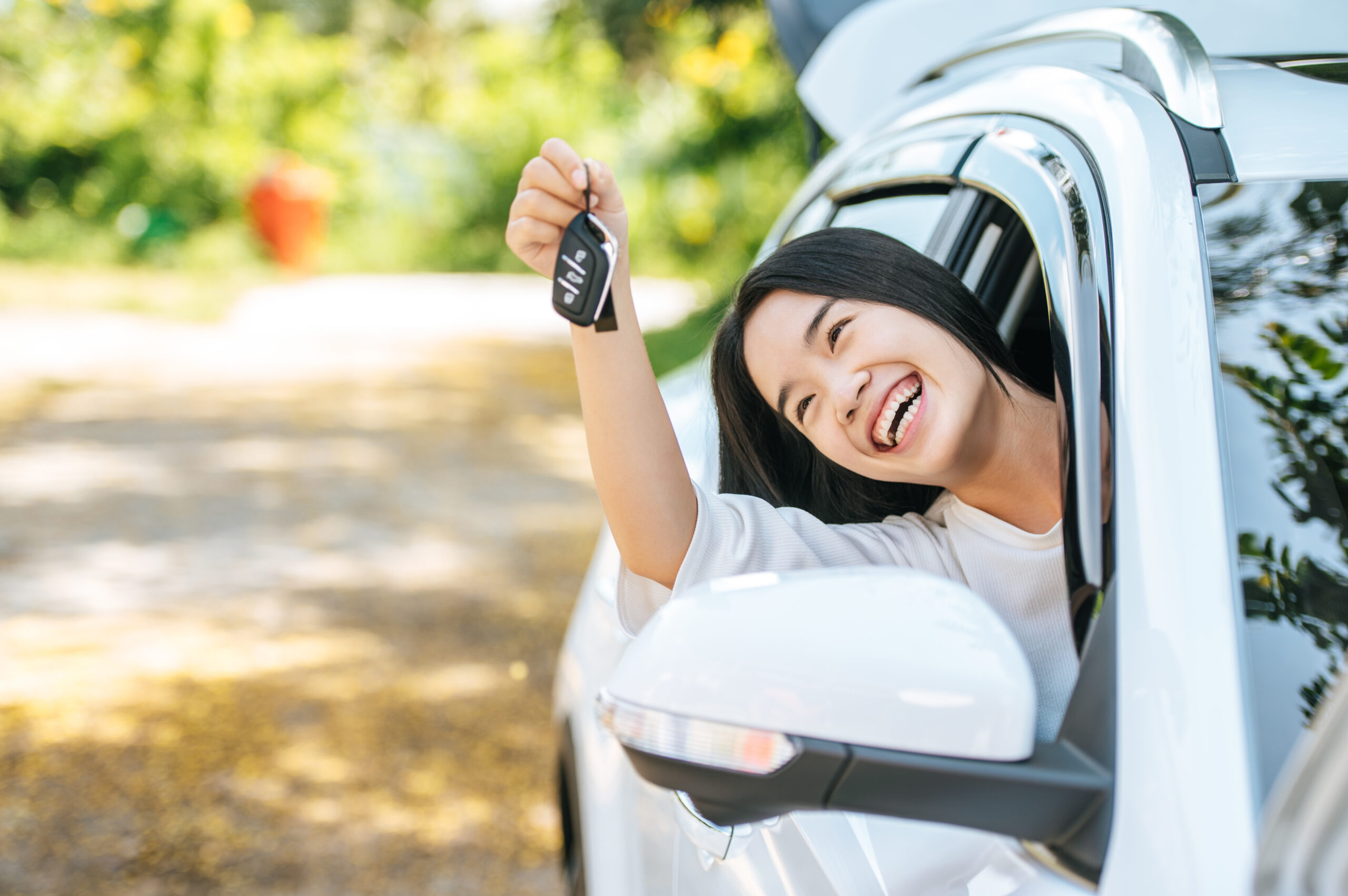 girl-sitting-car-holding-car-keys-hands-out-car-scaled.jpg